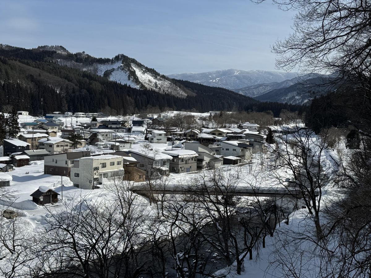 La città termale di Onogawa Onsen coperta di neve, con le montagne sullo sfondo