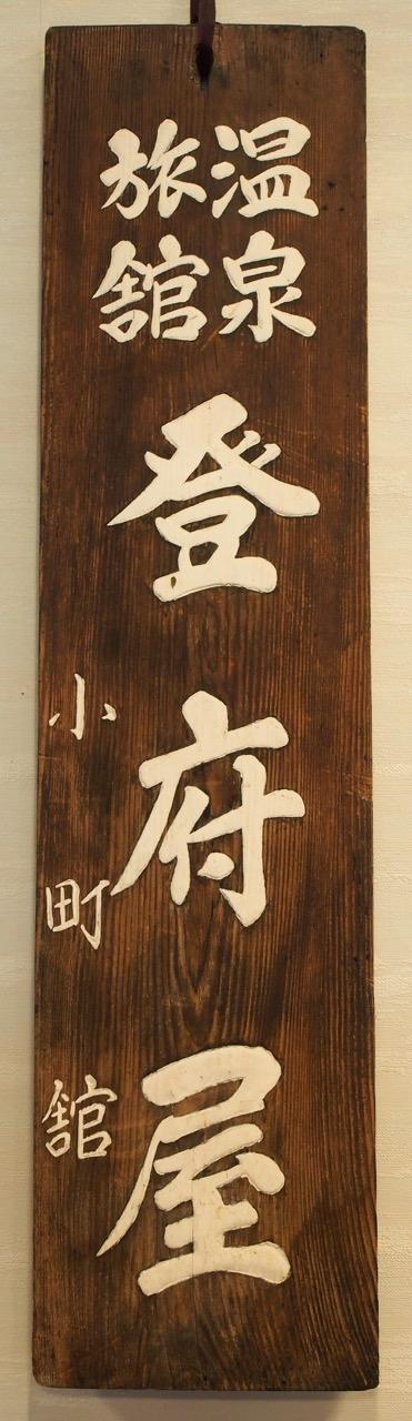 Papan nama kayu tua bertuliskan ‘Onsen Ryokan Tofuya’
