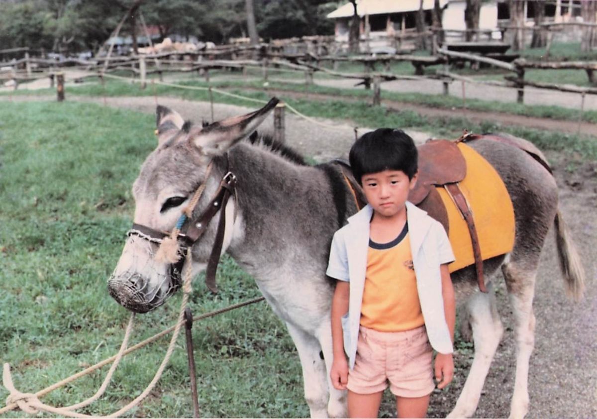 Naoto kecil berdiri di samping seekor keledai