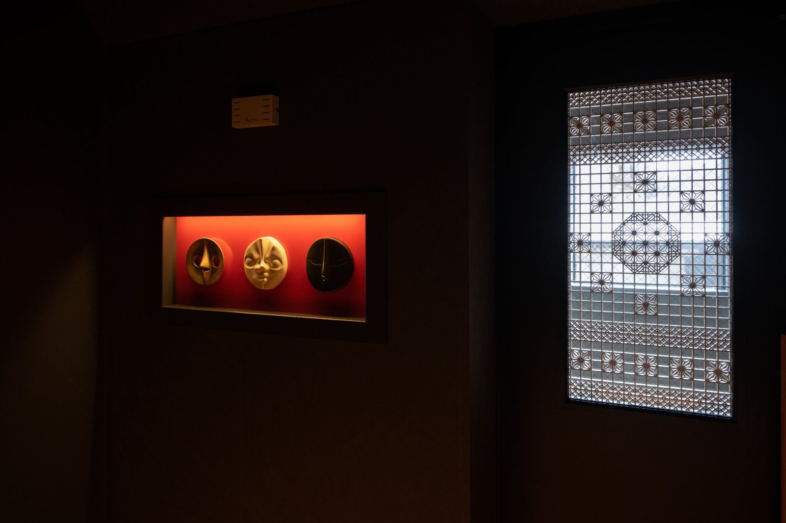 Una puerta de celosía kumiko y un objeto que brilla con la luz